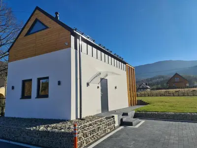 a small white building with a door on the side at Zawobaja in Zawoja