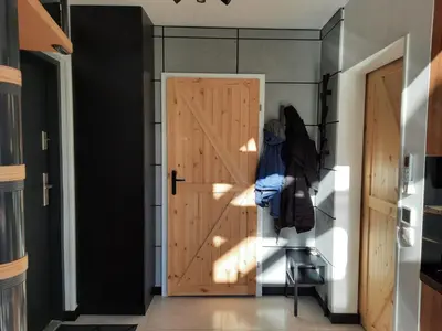 a hallway with a wooden door and a chair at Zawobaja in Zawoja