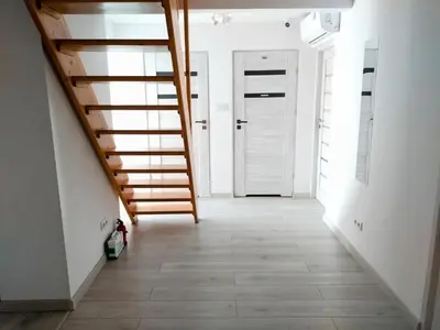 a hallway with a staircase and a white door at Sleep In Center in Kraków