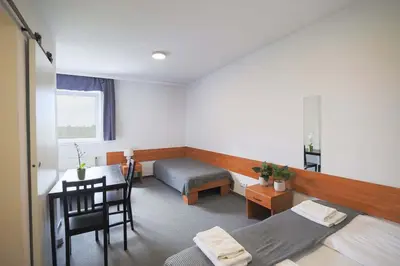 a room with a bed and a desk and a table at Hotel pod Wieliczką in Gdów