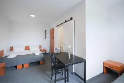 a bedroom with a bed and a table and a bed at Hotel pod Wieliczką in Gdów