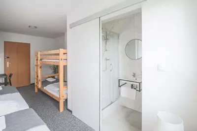 a bedroom with a bunk bed and a bathroom at Hotel pod Wieliczką in Gdów