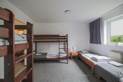 a room with three bunk beds and a window at Hotel pod Wieliczką in Gdów