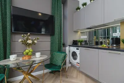 a kitchen with a table and a washing machine at Kazimierz Studio with Jacuzzi by Renters Prestige in Kraków