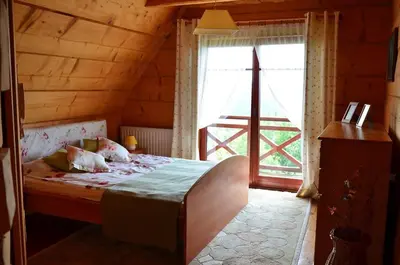 a bedroom with a bed and a large window at Góralska Ostoja in Pcim