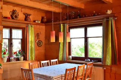 a dining room with a table and chairs and windows at Góralska Ostoja in Pcim
