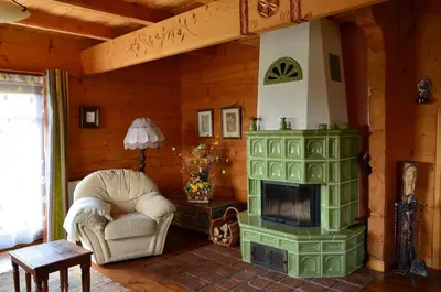 a living room with a green fireplace and a chair at Góralska Ostoja in Pcim