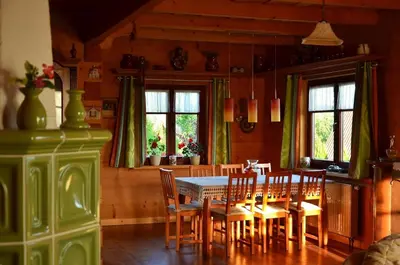 a dining room with a table and chairs and windows at Góralska Ostoja in Pcim