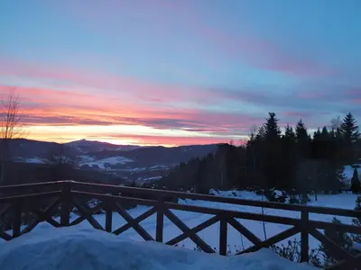 a sunset in the mountains with snow on the ground at Góralska Ostoja in Pcim