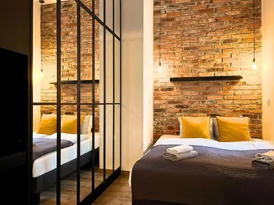 a bedroom with two beds and a brick wall at Large 75 m2 Apartment for 6 guests next to Wawel Castle in Kraków