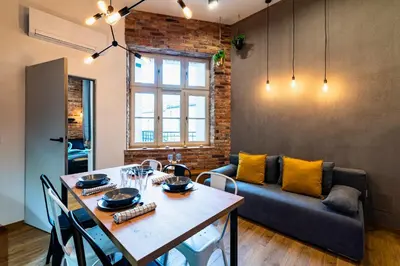 a living room with a table and a couch at Large 75 m2 Apartment for 6 guests next to Wawel Castle in Kraków