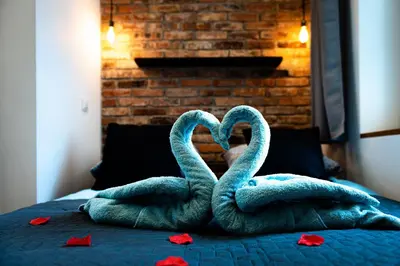 two towels shaped like swans sitting on a bed at Large 75 m2 Apartment for 6 guests next to Wawel Castle in Kraków