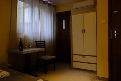 a room with a table and a chair and a window at City Apartment Getta in Kraków