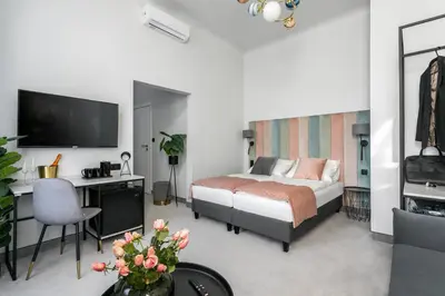 a bedroom with a bed and a desk and a tv at Old Town Residence - Premium Aparthotel in Kraków
