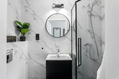 a bathroom with a sink and a shower with a mirror at Old Town Residence - Premium Aparthotel in Kraków