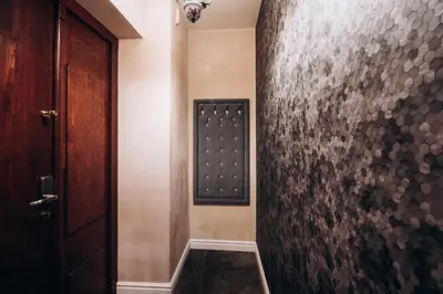a hallway with a door and a wall with a pattern at Native Apartments Dunajewskiego 2 in Kraków