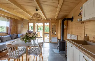 a kitchen and living room with a table and a stove at Domki pod Halą Krupową in Ohłypów