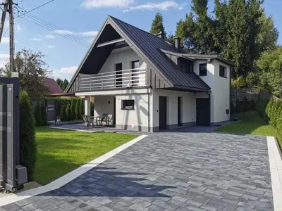 a white house with a black roof and a driveway at Dream House 8 osób - cały dla Ciebie in Gdów