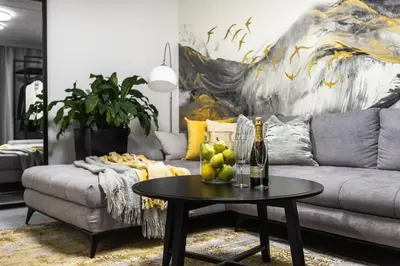 a living room with a couch and a table with a bottle of wine at Family Center Apartments in Kraków