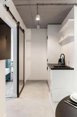 a white kitchen with a sink and a counter at Family Center Apartments in Kraków