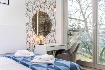 a bedroom with a mirror and a bed and a chair at Apartamenty na Dębnikach - by Upstairs in Kraków