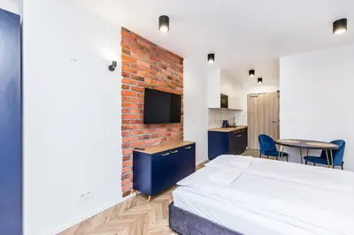 a bedroom with a bed and a brick wall at Apartamenty na Dębnikach - by Upstairs in Kraków