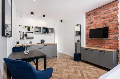 a kitchen with a brick wall and a table and chairs at Apartamenty na Dębnikach - by Upstairs in Kraków