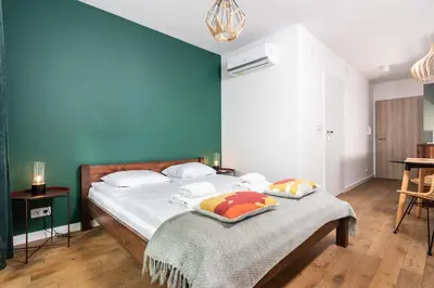 a bedroom with a bed with a blue wall at Apartamenty na Dębnikach - by Upstairs in Kraków