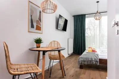 a room with a table and two chairs and a bed at Apartamenty na Dębnikach - by Upstairs in Kraków