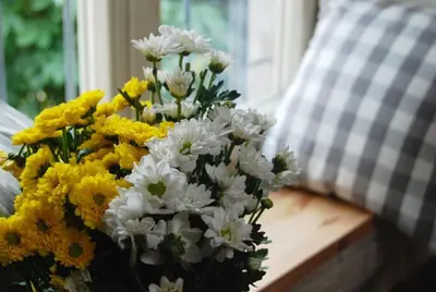 a bouquet of yellow and white flowers on a table at Stay in the Heart of Kraków in Kraków