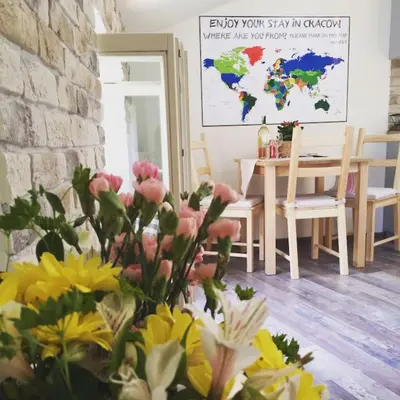 a vase of flowers in a room with a table at Stay in the Heart of Kraków in Kraków