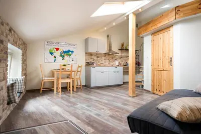 a bedroom with a bed and a kitchen with a table at Stay in the Heart of Kraków in Kraków