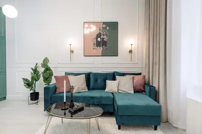 a living room with a blue couch and a table at Krakow Old Town Apartments in Kraków