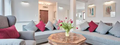 a living room with couches and a vase of flowers on a table at Family Apartment by Tyzenhauz in Kraków