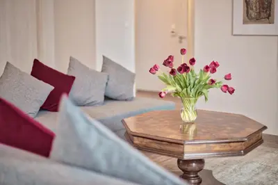 a vase of flowers on a table in a living room at Family Apartment by Tyzenhauz in Kraków