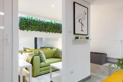 a living room with a green couch and a table at Cosy Apartment in Perfect Location in Kraków