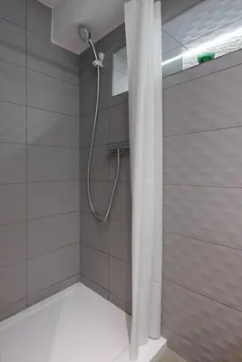 a shower with a shower head in a bathroom at Cosy Apartment in Perfect Location in Kraków