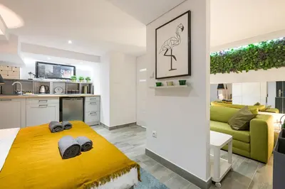a bedroom with a yellow bed and a kitchen at Cosy Apartment in Perfect Location in Kraków