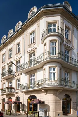 a large white building with balconies on top of it at Cosy Apartment in Perfect Location in Kraków