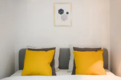 a bedroom with two yellow pillows and a bed at Cosy Apartment in Perfect Location in Kraków