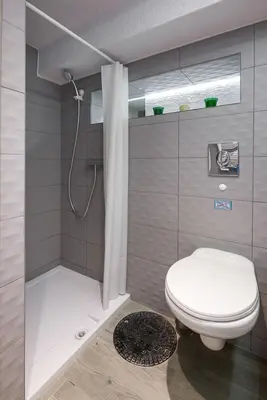 a small bathroom with a toilet and a shower at Cosy Apartment in Perfect Location in Kraków