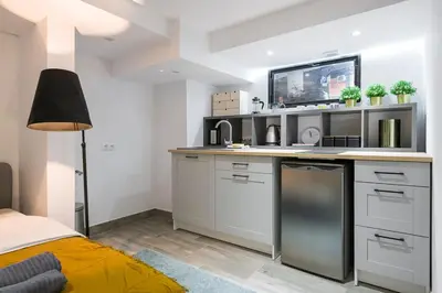 a kitchen with white cabinets and a counter top at Cosy Apartment in Perfect Location in Kraków