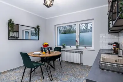 a kitchen and dining room with a table and chairs at Exclusive Apartment Centrum 2 in Wadowice