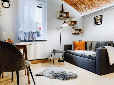 a living room with a blue couch and a window at Unique studio perfect for couples, Old Podgórze in Kraków