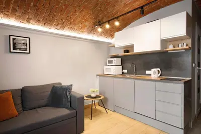a living room with a couch and a kitchen at Unique studio perfect for couples, Old Podgórze in Kraków