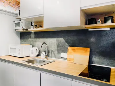 a kitchen with white cabinets and a sink at Unique studio perfect for couples, Old Podgórze in Kraków