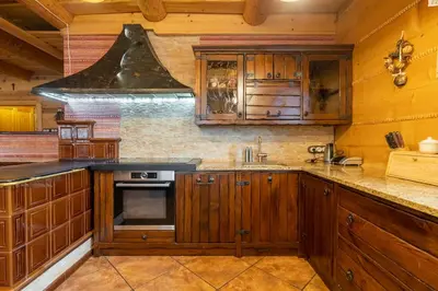 a kitchen with wooden cabinets and a stove at Willa Sołdrówka in Kocierz Rychwałdzki