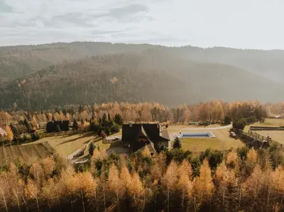 a house in a field with a mountain in the background at Willa Sołdrówka in Kocierz Rychwałdzki
