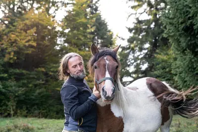 a man standing next to a brown and white horse at Górna Chata Mountains Chalet - Stable Cottage in Ochotnica Górna