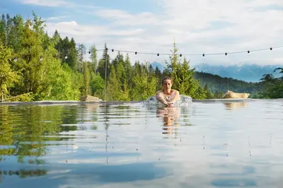 a woman floating in a body of water at Górna Chata Mountains Chalet - Stable Cottage in Ochotnica Górna